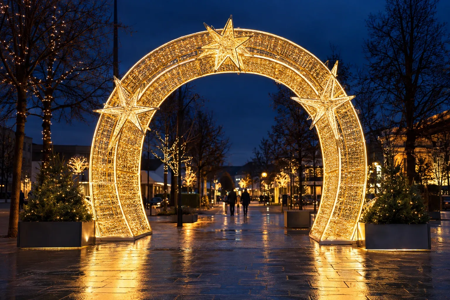 A walk-through arch skinned in gold mesh and lit warm white, with stars on it, over a paved path at night